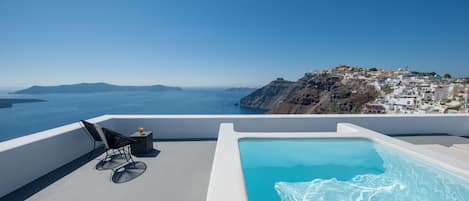 A rooftop infinity pool with a clear view of the sea and a distant island.