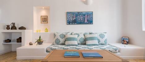 A modern living room with a sofa, a coffee table, and a bookshelf.