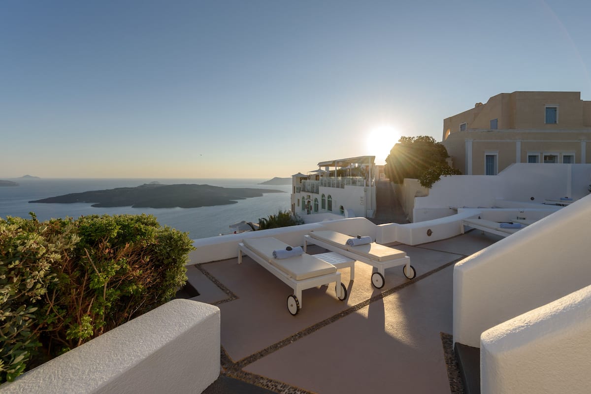 A rooftop terrace with sun loungers and a view of the sea.