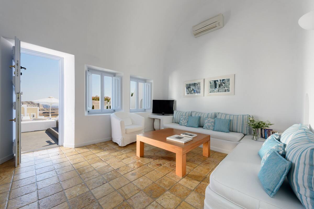 A modern living room with a sofa, a coffee table, a TV, and a chair.