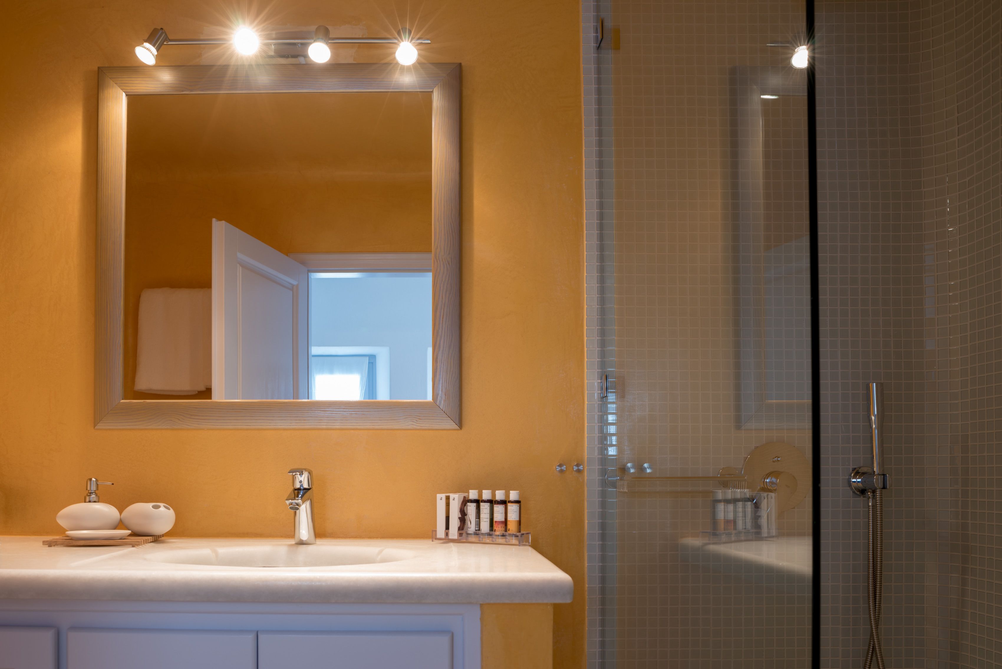 A bathroom with a white sink, a large mirror, and a shower area.