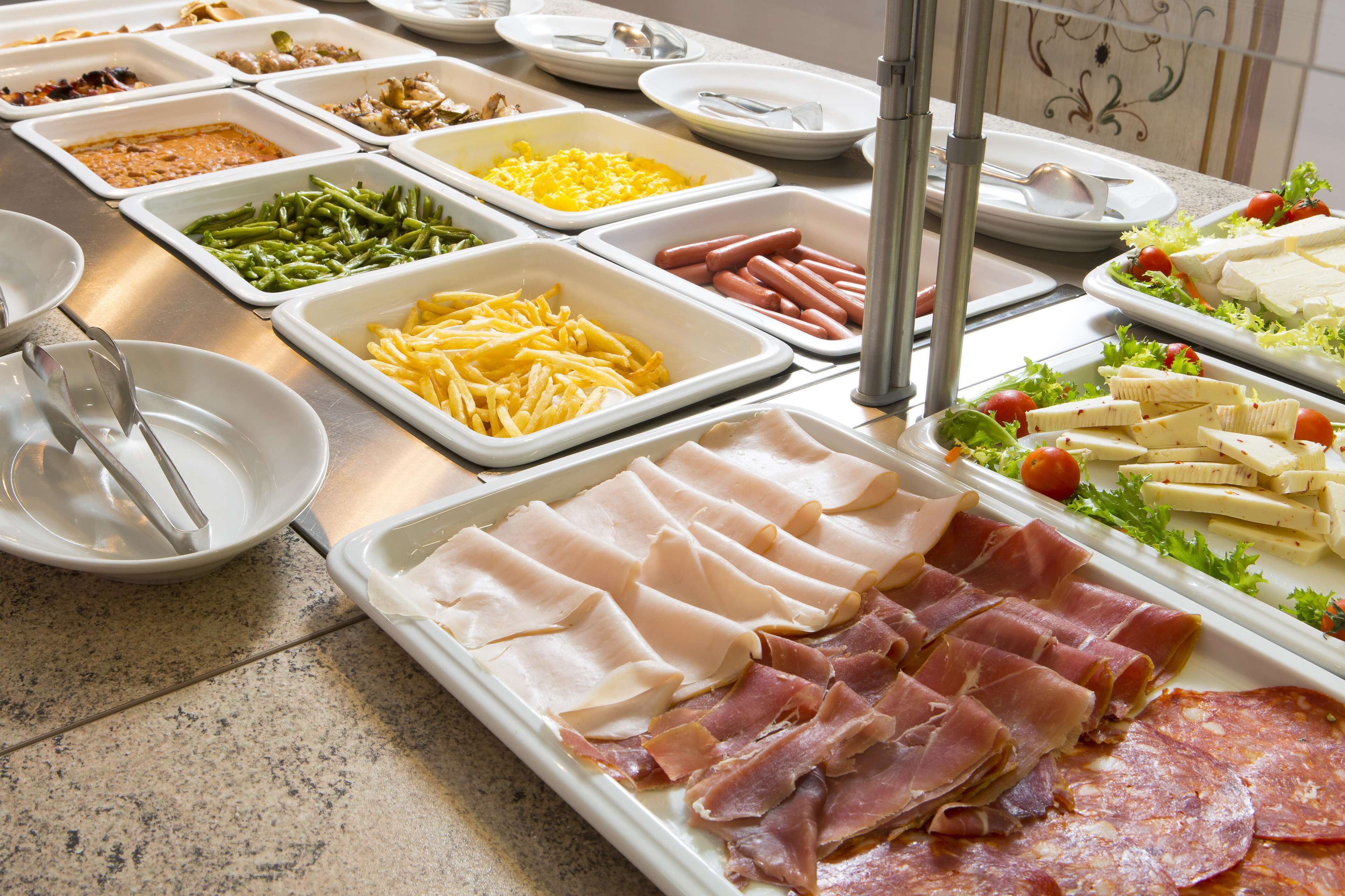 A buffet with various food items including meats, cheeses, and vegetables.
