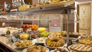 Un buffet proposant une variété de plats, notamment des pâtisseries, des fruits et des desserts.