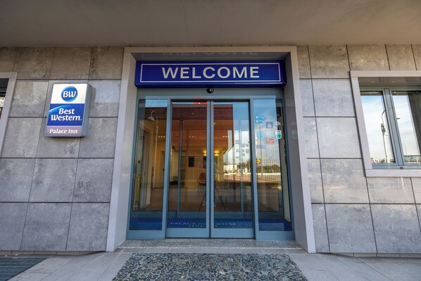 The entrance to the Best Western Palace Inn with a 'WELCOME' sign above the doors. - Best Western Palace Inn Hotel (Ferrara)