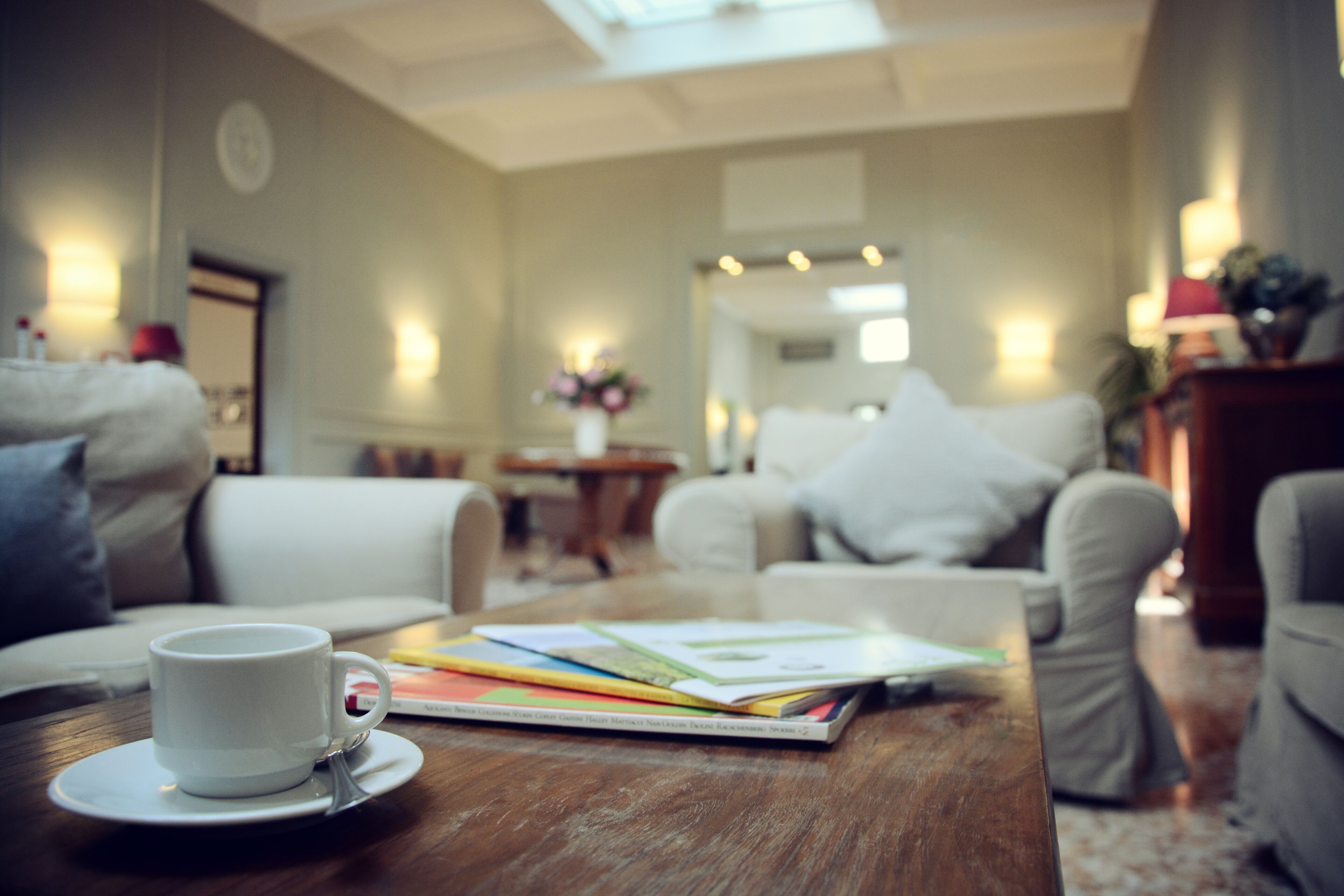 Una sala de estar acogedora con una mesa de centro, una taza blanca y un libro.