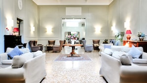 A spacious lobby with a central table, seating arrangements, and a large mirror. - Hotel Touring Wellness & Beauty (Fiuggi)