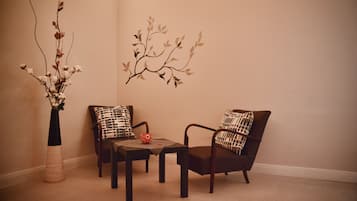 Una habitación con un sofá, una mesa de centro y un jarrón con ramas.