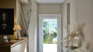 A hallway with a reception desk, a door leading outside, and a glass display case with decorative items. - Hotel Touring Wellness & Beauty (Fiuggi)
