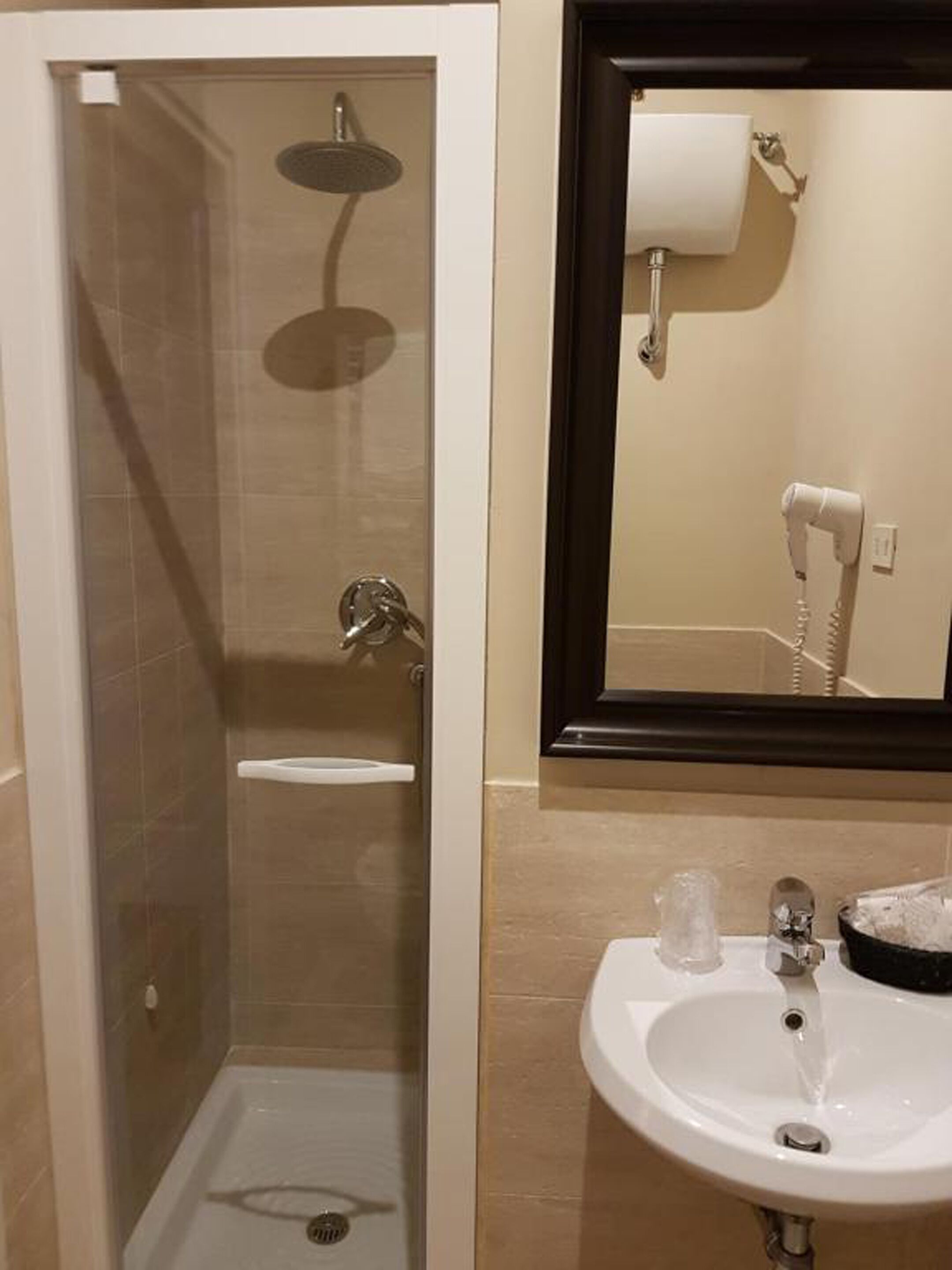 Un bany amb dutxa, un lavabo i un mirall.