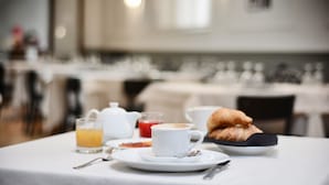 A breakfast setting with a cup of coffee, croissants, and a glass of orange juice on a table. - Hotel Touring Wellness & Beauty (Fiuggi)