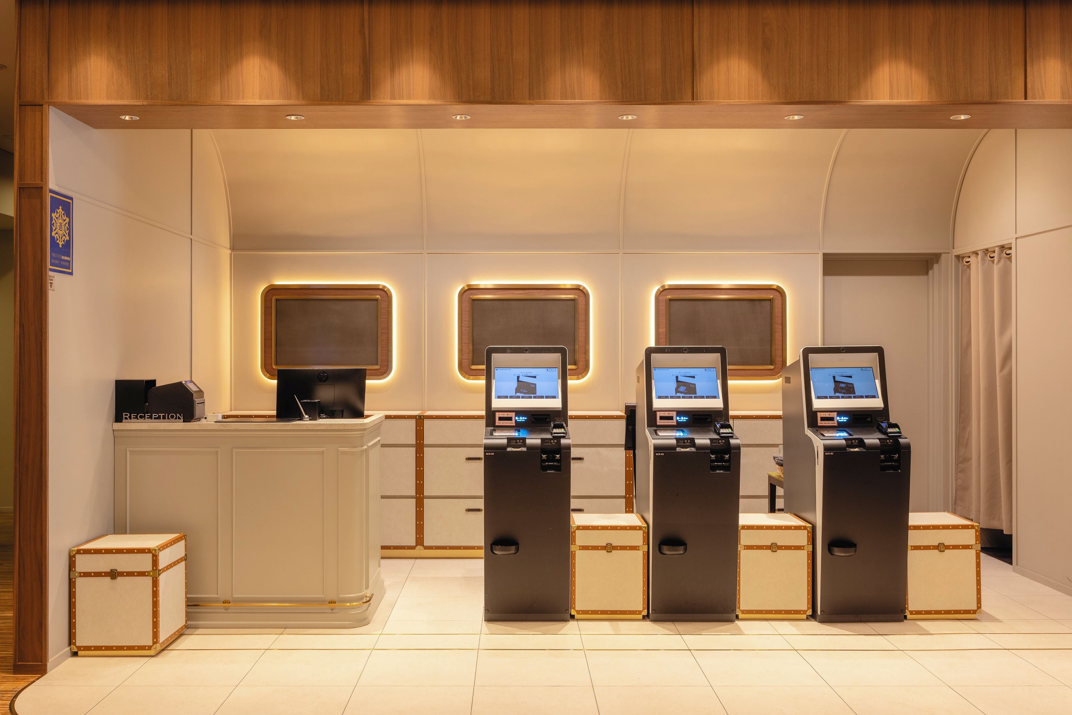 A reception area with a reception desk and three self-service kiosks.