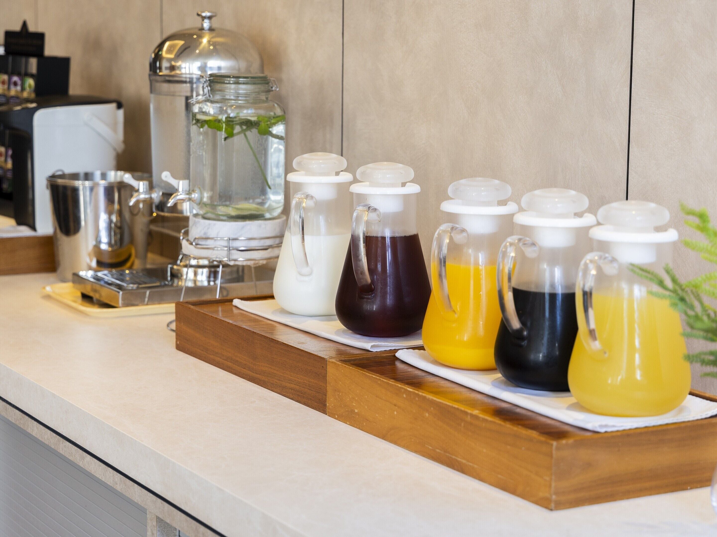 A beverage station with various drink dispensers and a coffee maker.