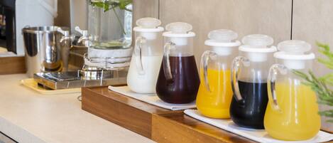 A beverage station with various drink dispensers and a coffee maker.