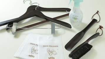 A shoe care kit with a spray bottle, brush, polish, and hangers.