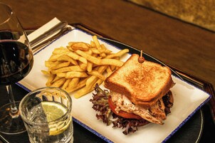 A plate with a sandwich, fries, and a drink.