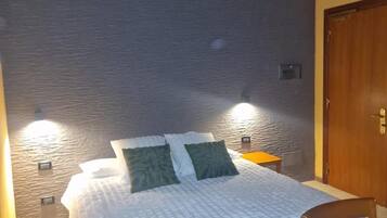 Ein Zimmer mit einem Bett, einem Holzstuhl und einer Tür.