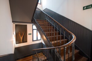 A staircase with wooden steps and black balusters, leading to a lower level.