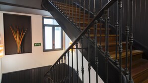 Una escala de fusta amb barana corba i rils negres.