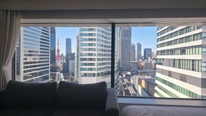 Ein Hotelzimmer mit großem Fenster und Blick auf die Stadt.