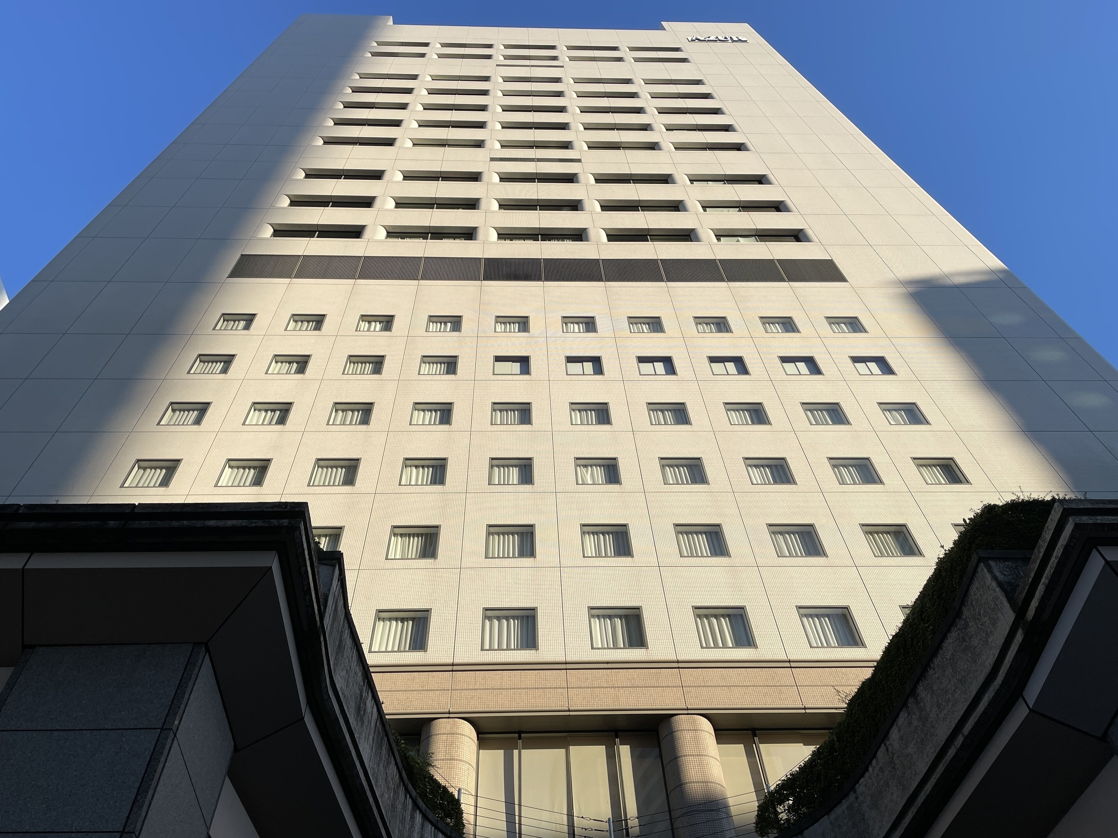 A tall, modern building with a grid of windows and a prominent "AZUL" sign at the top.