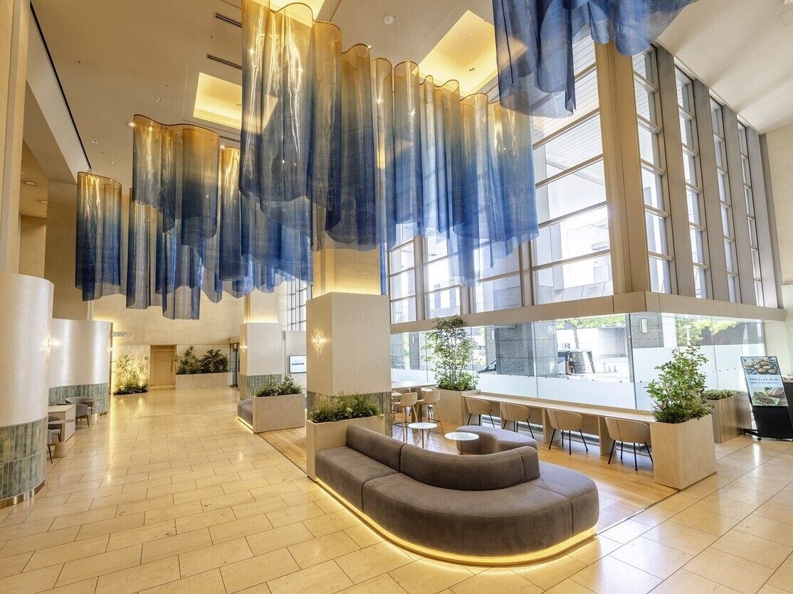 A spacious lobby with a curved sofa, seating area, and large windows.