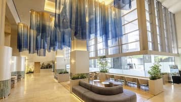 A spacious lobby with a curved sofa, seating area, and large windows.