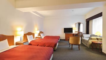 Una habitación de hotel con dos camas, televisor, escritorio, silla y sofá.