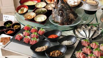 A variety of dishes including sashimi, eggs, and fish on a table.