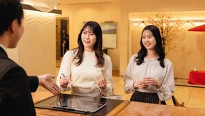 A reception area with a reception desk, a tablet, and a person handing over a device. - Yokohama Sakuragicho Washington Hotel (Yokohama)