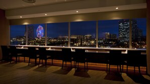 A modern hotel room with a large window overlooking a cityscape at night, featuring a brightly lit Ferris wheel. - Yokohama Sakuragicho Washington Hotel (Yokohama)