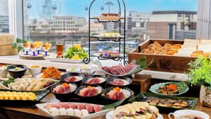 A variety of Japanese cuisine including sushi, sashimi, and tempura, displayed on a table with a city view in the background. - Yokohama Sakuragicho Washington Hotel (Yokohama)