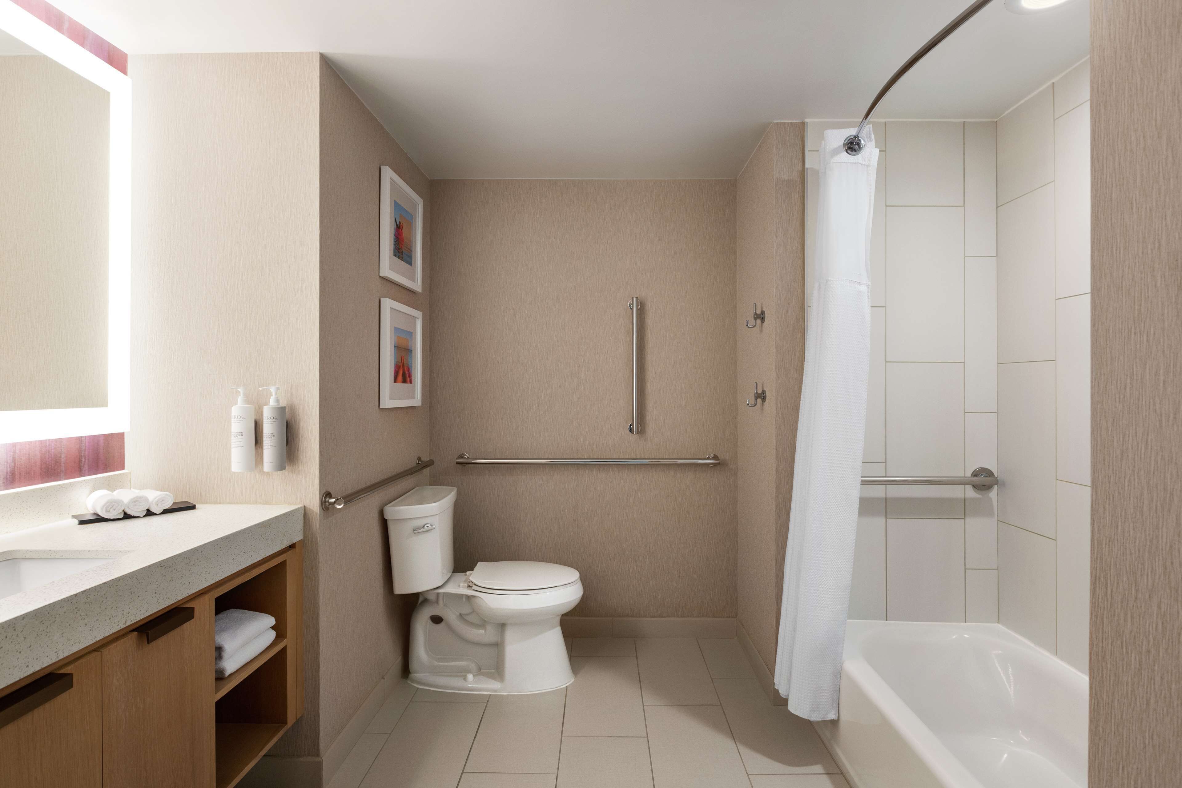 A modern bathroom with a toilet, sink, and bathtub.