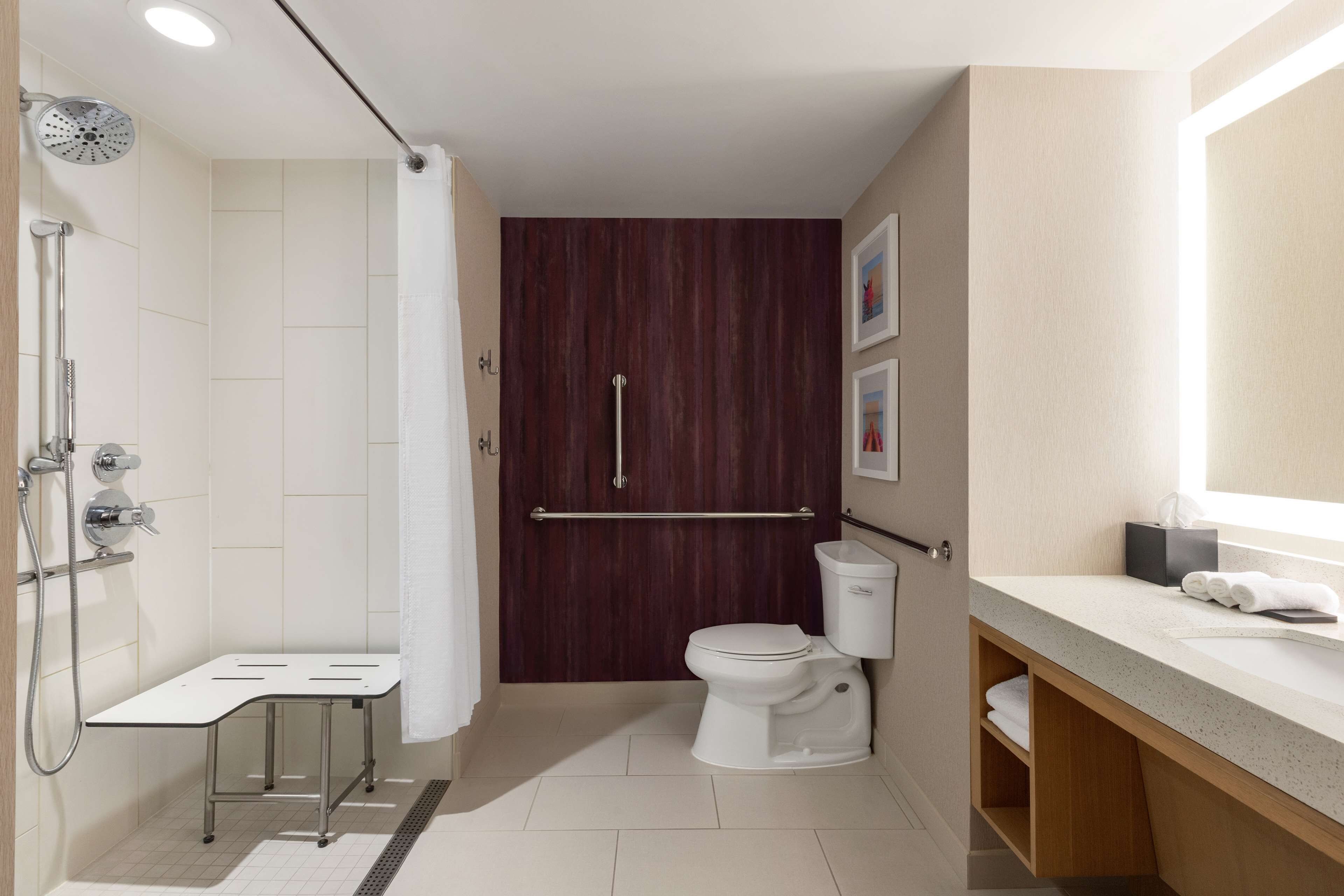 A modern bathroom with a shower, toilet, and vanity.
