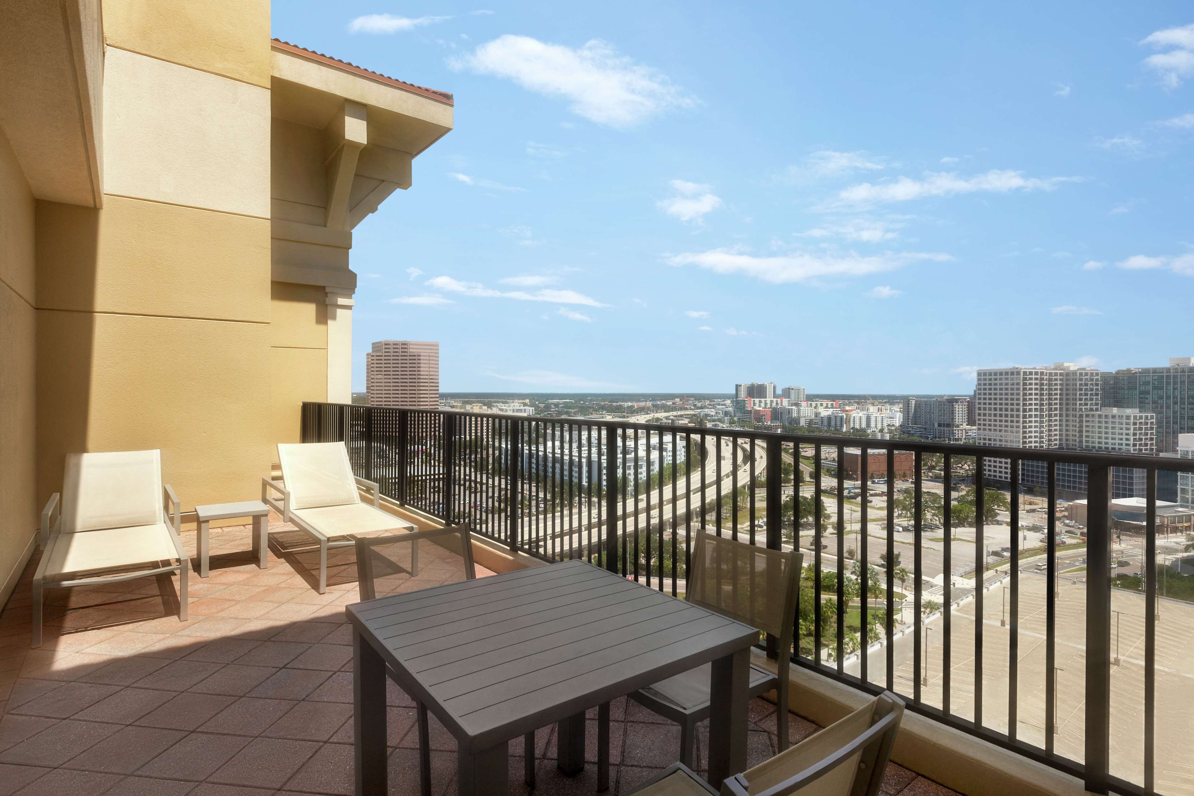 Un balcon avec une table et des chaises, d’où l’on peut admirer la vue sur la ville.