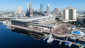A waterfront hotel with a convention center, marina, and city skyline in the background.