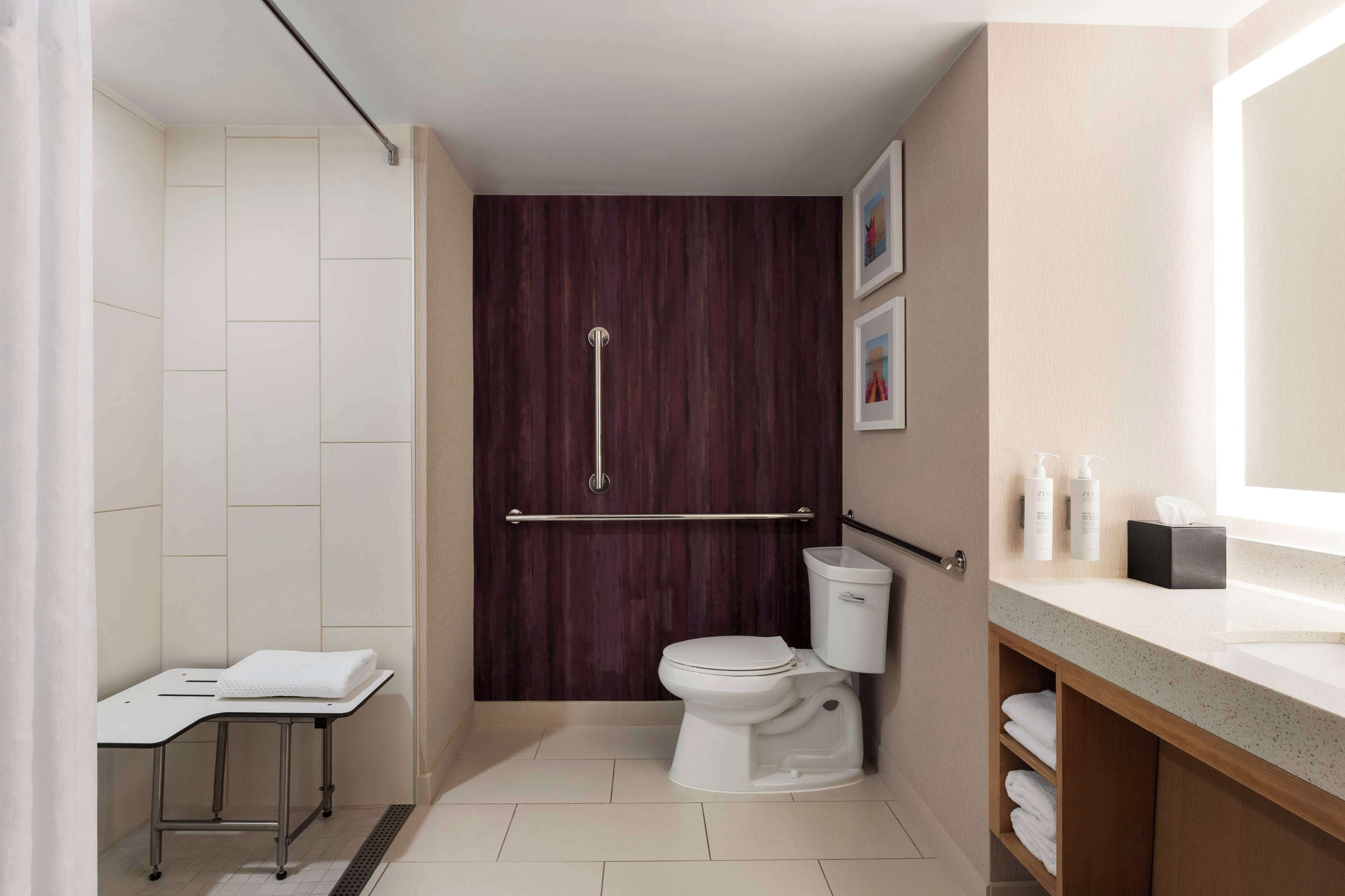 Une salle de bain moderne équipée d’une douche, de toilettes et d’un meuble-lavabo.
