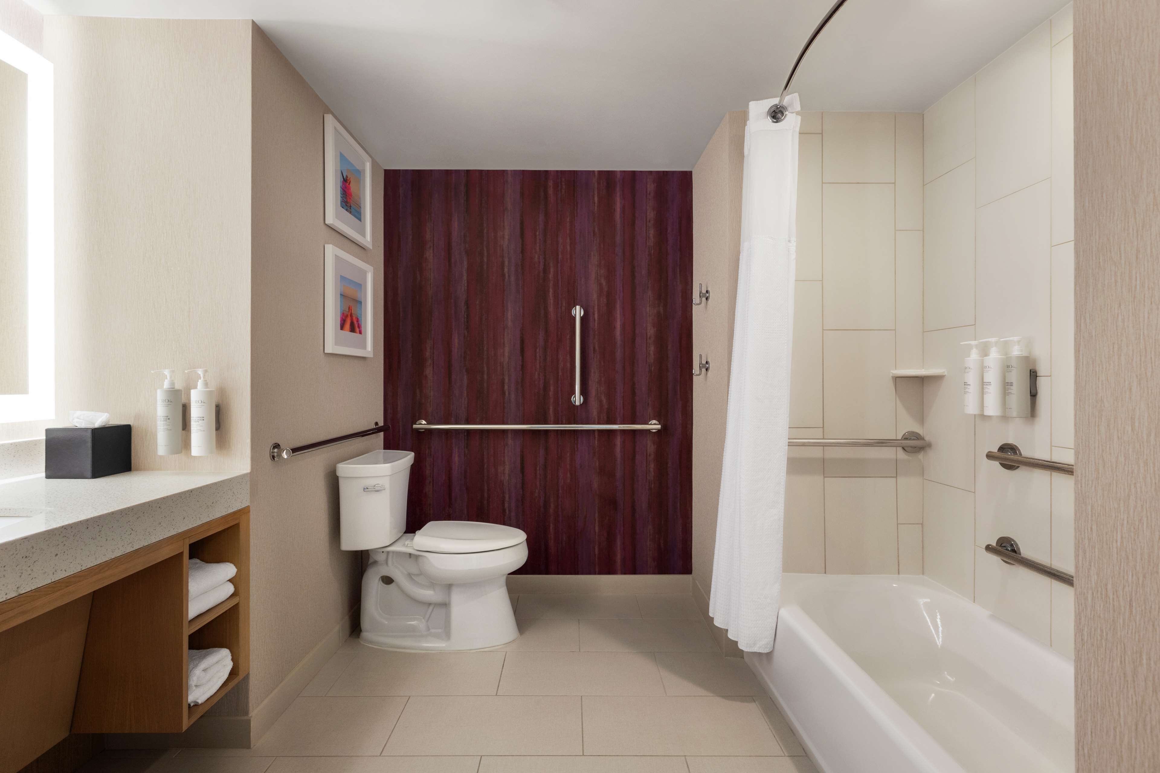 Un baño moderno con inodoro, bañera y zona de ducha.