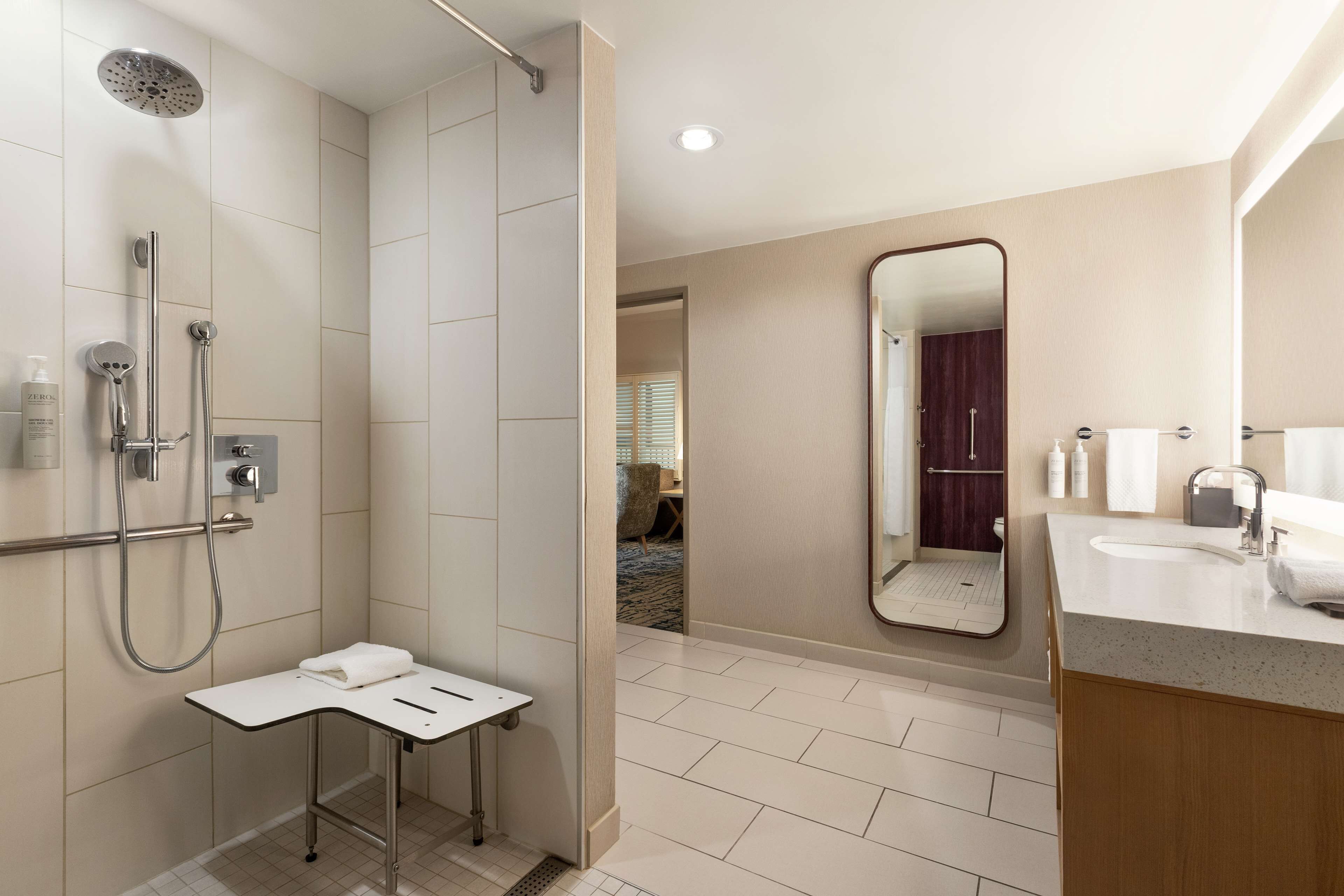 A modern bathroom with a shower, toilet, and sink.