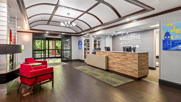 A reception area with a wooden reception desk, red chairs, and a modern ceiling design. - Hampton Inn & Suites Richmond/Virginia Center (Glen Allen)