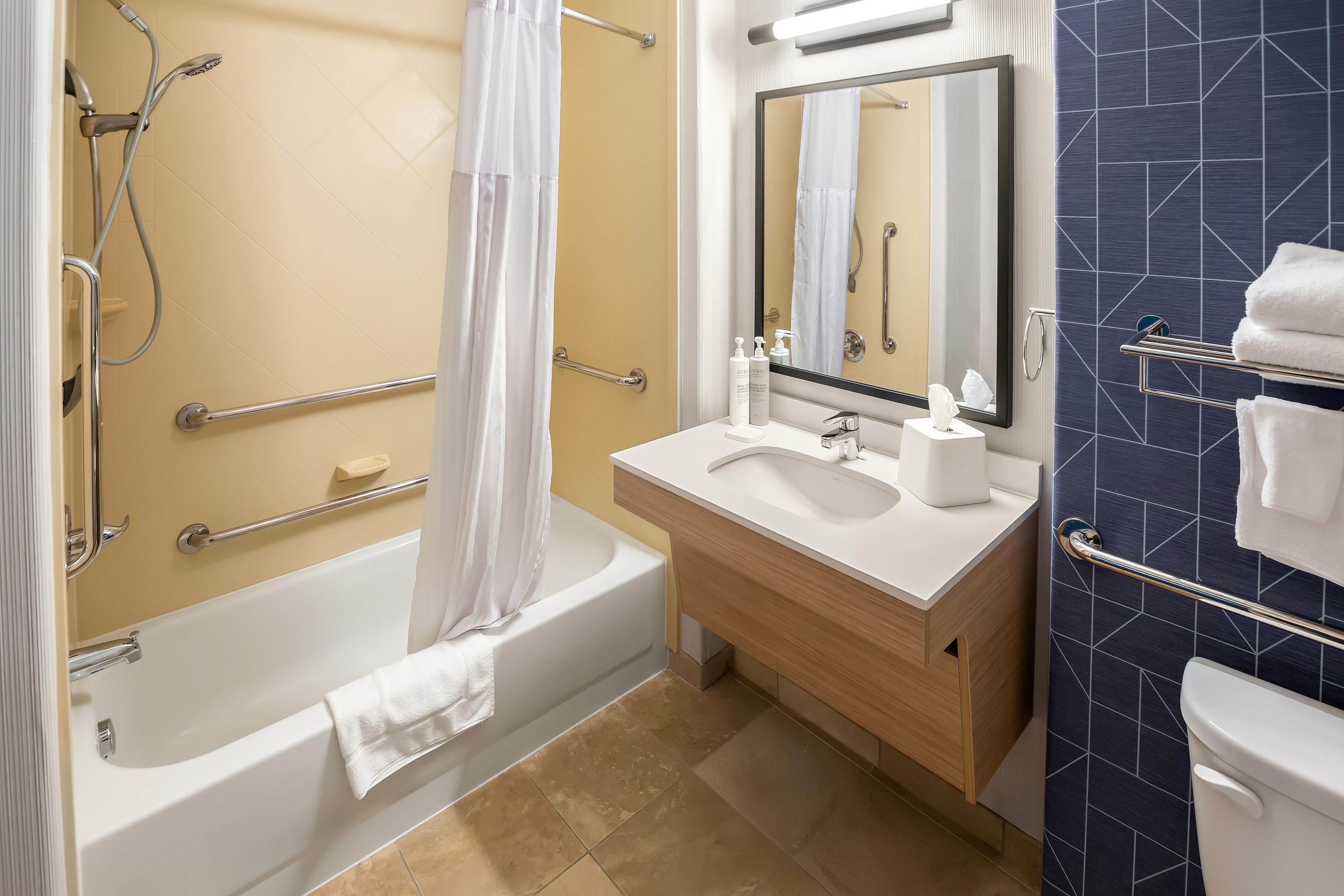 A bathroom with a bathtub, a shower, a sink, and a toilet.