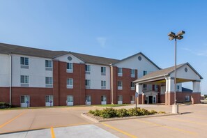 A multi-story hotel with a covered entrance and a parking lot. - Spark by Hilton Grand Island (Grand Island)