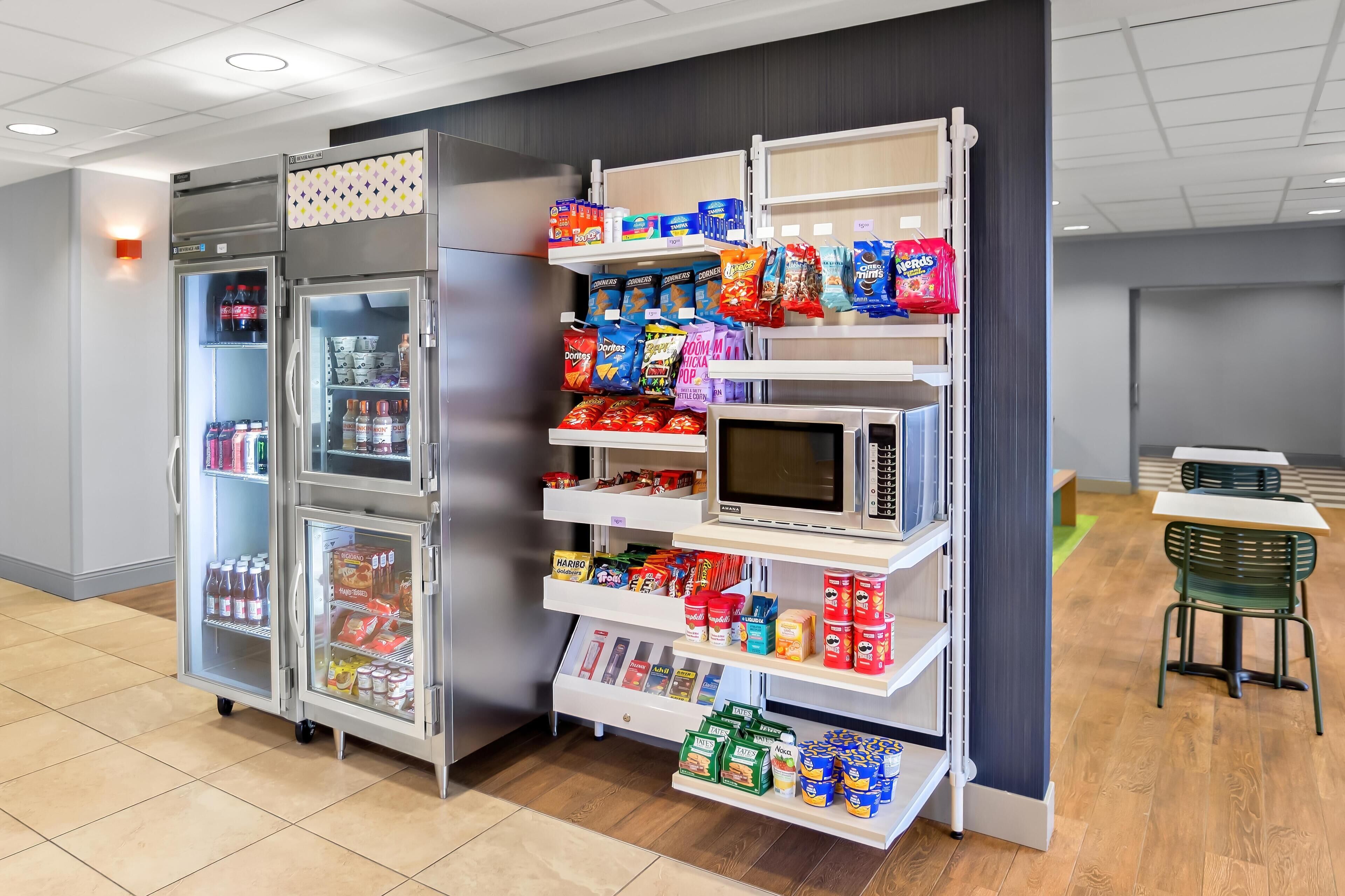 A vending machine area with snacks, drinks, and a microwave.