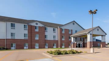 A multi-story hotel with a covered entrance and a parking lot.
