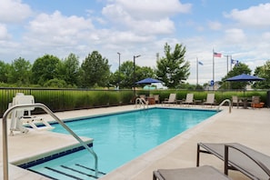 A swimming pool with a lifeguard stand, lounge chairs, and umbrellas. - Hampton Inn Farmville, VA (Farmville)