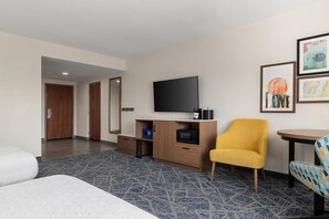 A hotel room with a bed, a television, a small desk with a microwave, a yellow armchair, and a framed picture on the wall. - Hampton Inn Farmville, VA (Farmville)