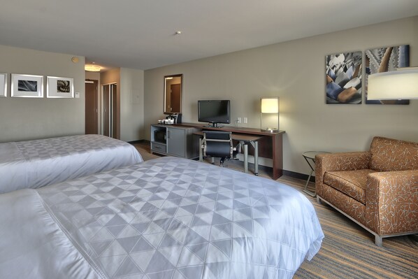 A hotel room with two beds, a desk with a computer, a chair, and artwork on the walls. - Holiday Inn & Suites Albuquerque-North I-25 by IHG (Albuquerque)