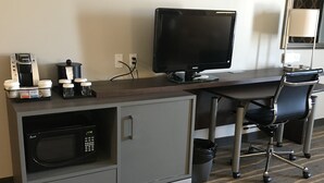 Ein Hotelzimmer mit Küchenzeile, Schreibtisch mit Computer und Stuhl.