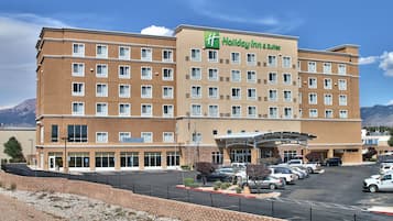 Experience the sleek, modern design of this hotel, featuring a symmetrical facade and landscaped entrance.