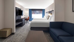 A hotel room with a bed, a desk with a chair, a TV, and a sofa. - Holiday Inn Express St. Petersburg North (I-275) by IHG (St. Petersburg)