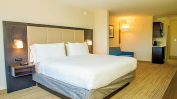 A hotel room with a large bed, bedside tables, a desk, and a chair.